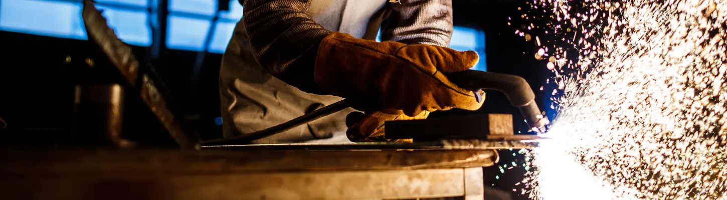 man plasma cutting metal